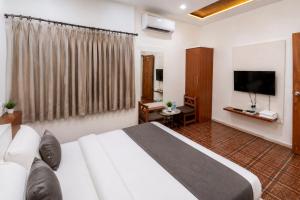 a hotel room with a bed and a television at Hotel Bhakti Rajkot I Hotel in Rajkot I Best Hotel in Rajkot in Rajkot