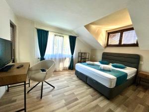 a bedroom with a bed and a desk and a computer at Къща Петя село Орешак in Troyan