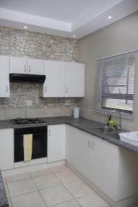 a kitchen with white cabinets and a sink at Nao's Place in Dorchester Heights 