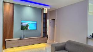 a living room with a couch and a flat screen tv at Nao's Place in Dorchester Heights 