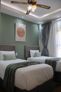 a bedroom with two beds and a ceiling fan at Nao's Place in Dorchester Heights 