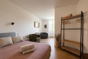 a bedroom with a bed and a couch and a chair at Le Bellevue in Excénevex