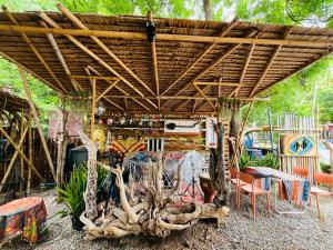 a patio with a wooden roof with trees and chairs at Zulu land Kohlarn in Ko Lan