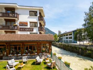a hotel with chairs and tables in front of a building at Hôtel de L'Arve by HappyCulture in Chamonix