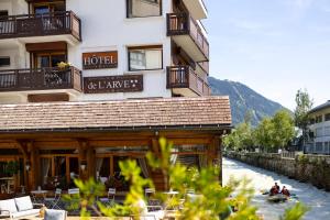 a hotel with a river in front of a building at Hôtel de L'Arve by HappyCulture in Chamonix