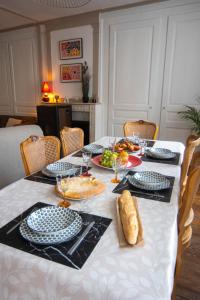 a white table with plates of food on it at L'échappée Jurassienne - Tout équipé au calme in Saint-Claude +10 photos