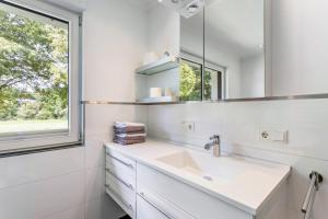 a white bathroom with a sink and a mirror at Fewo Wrede am Sauerland-Radring 1 in Wenholthausen +34 photos