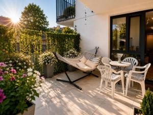 a patio with a hammock and chairs and a table at Augustowskie Apartamenty Blisko Jezior i Lasów oraz Bezpłatny parking in Augustów