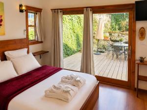 a bedroom with a bed and a balcony with a table at BeLev Odem in Odem