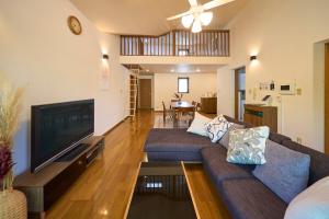 a living room with a couch and a flat screen tv at Suite Villa Panora Yatsugatake in Minamimaki