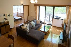 a living room with a couch and a table at Suite Villa Panora Yatsugatake in Minamimaki