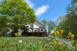 a house in the middle of a field with flowers at Suite Villa Panora Yatsugatake in Minamimaki