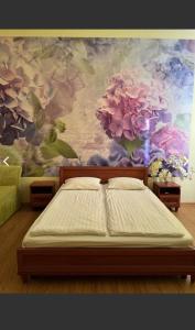 a bed in a room with a painting of flowers at Готель Аркан in Kolomiya