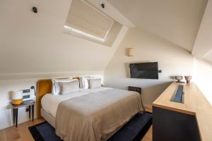 a bedroom with a bed and a flat screen tv at Faubourg 21 - The Leading Hotels of the World in Brussels