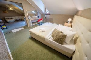 a bedroom with a large bed and a living room at Penzión Aira in Zvolen