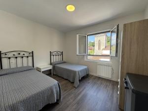 a bedroom with two beds and a window at Alojamiento Picos de Europa VUT-2458-AS in Arriondas
