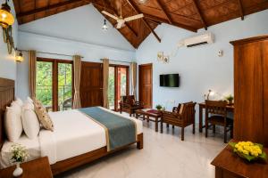 a bedroom with a bed and a dining room at Hill Crest Resort - Coorg in Madikeri