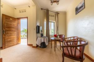 a living room with a table and chairs and a door at Moriah Hill Resort in Kibuye