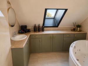 a bathroom with a sink and a tub and a window at Wilgenhof Boutique Hotel "volledig vernieuwd en onder nieuw beheer" in Maaseik