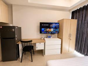 a kitchen with a desk and a television in a room at Modern studio with a stûnning view at 32 floor in Jakarta