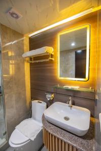 a bathroom with a sink and a toilet and a mirror at EGI Cebu Resort and Hotel in Maribago