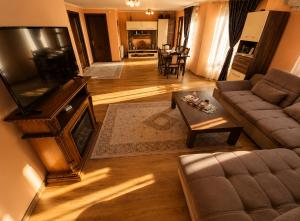 a living room with a couch and a tv at Casa Dragomir in Plaiu Şarului +12 photos