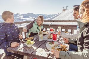 a group of people sitting around a table eating food at Schwaighof in Oberau