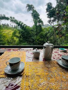 a table with cups and saucers on a table with a view at Ella Hermitage View in Ella +49 photos