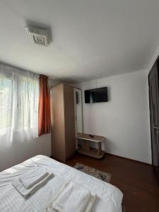 a bedroom with a bed with two towels on it at Colț de Vâlsan in Brăduleţ