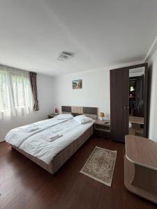 a bedroom with a large bed and a table at Colț de Vâlsan in Brăduleţ