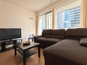 a living room with a couch and a flat screen tv at Toronto Skyline Center Hotel in Toronto