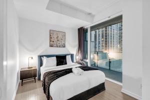 a bedroom with a large bed and a large window at Toronto Skyline Center Hotel in Toronto