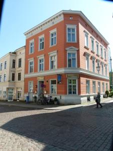 
a large brick building with a clock on the front of it at Hotel Amber Altstadt in Stralsund
