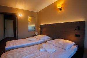 a hotel room with two beds and a mirror at Parkova - pokoje hotelowe in Gołdap