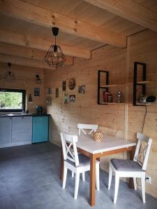 a kitchen and dining room with a table and chairs at Domki Dobrogoszcz in Dobrogoszcz +30 photos