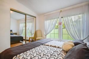 a bedroom with a large bed and a large window at Ferienhaus Rauchfangswerder in Berlin