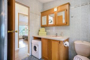 a bathroom with a sink and a washing machine at Ferienhaus Rauchfangswerder in Berlin +24 photos