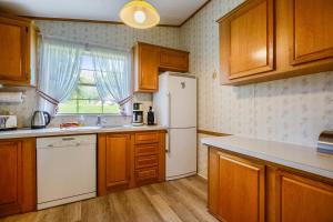 a kitchen with wooden cabinets and a white refrigerator at Ferienhaus Rauchfangswerder in Berlin