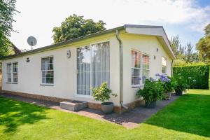 a white house with plants in a yard at Ferienhaus Rauchfangswerder in Berlin