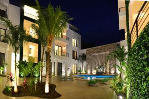 
a large building with palm trees and palm trees at Elements Tulum Boutique Hotel in Tulum
