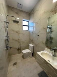 a bathroom with a toilet and a sink and a mirror at خالد للشقق in Ar Rass