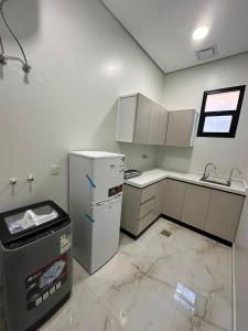 an empty kitchen with a refrigerator and a sink at خالد للشقق in Ar Rass