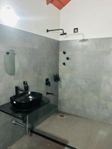 a bathroom with a sink and a shower at Janapriya Villa 2 in Mudigere