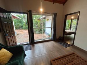 a living room with doors open to a patio at Janapriya Villa 2 in Mudigere +15 photos