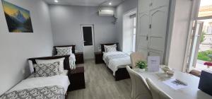 a room with two beds and a couch and a table at Registan Stay in Samarkand +17 photos