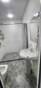 a white bathroom with a sink and a toilet at Registan Stay in Samarkand