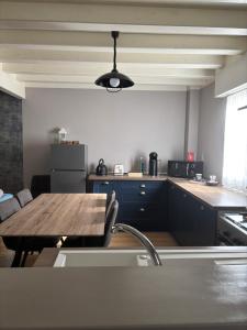 a kitchen with a wooden table and a counter top at LOGEMENT ENTIER Tilleul Suite in Fléac