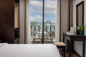 a hotel room with a bed and a view of a balcony at Golden Legend Boutique Hotel in Hanoi
