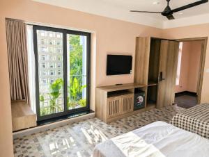 a bedroom with a bed and a tv and a window at 2MINZ Homestay in Thôn An Hòa