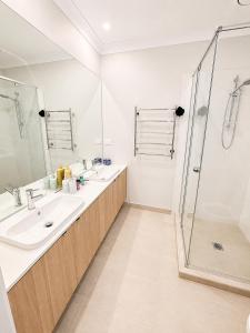 a bathroom with two sinks and a shower at 4 Bedrooms Home in Gledswood Hills +10 photos